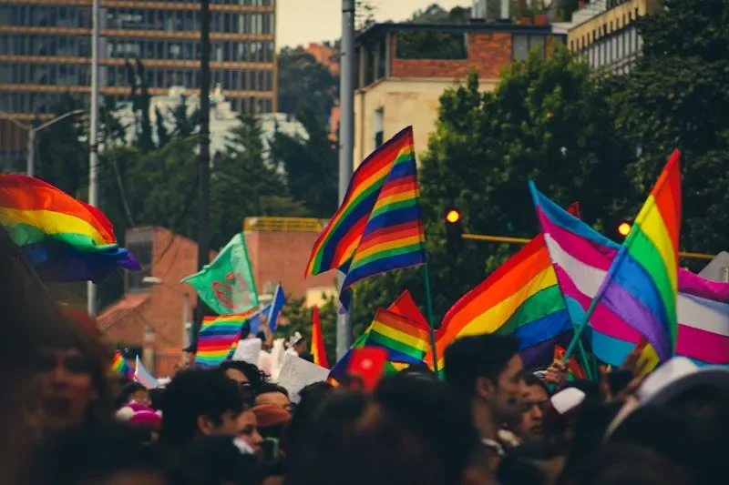 People with various rainbow flags. Photo by Christian Gutiérrez Martínez on Pexels.